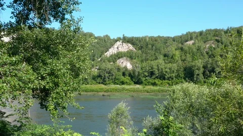 Copter flies between the trees to the river. 스톡 동영상 113695773