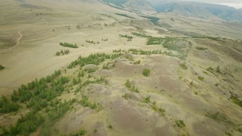 The copter flies high above the hilly desert area. Snowy mountains and rivers in Stock Footage 278367271