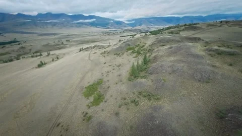 The copter flies high in the mountains over hills, rivers and forests. Cloudy Video stock 278368193