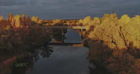 Copter flies over the bridge over the river, along which cars travel. Yellow Stock Footage 164924551