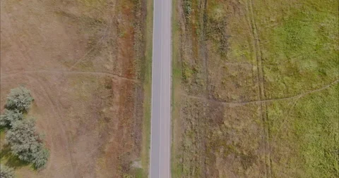 Copter flies over a country road between fields. Asphalt road, traveling by car Stock Footage 161761253