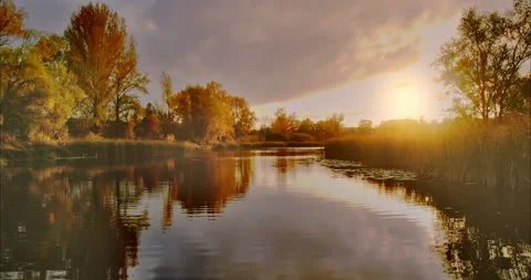 Copter flies over the lake in which the golden rays of the sun are reflected Stock Footage 164928114
