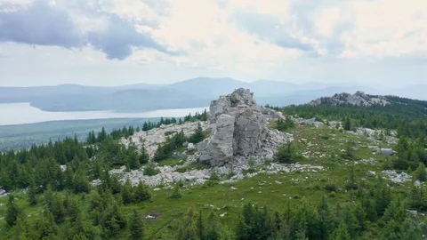 A copter flies over marble cliffs at the top of a mountain range. Stock Footage 114056666