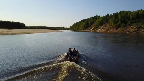 A copter flies over the river behind a motor boat. Stock Footage 256203341