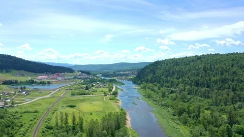 A copter flies over the river valley towards the village. Stock Footage 116669187