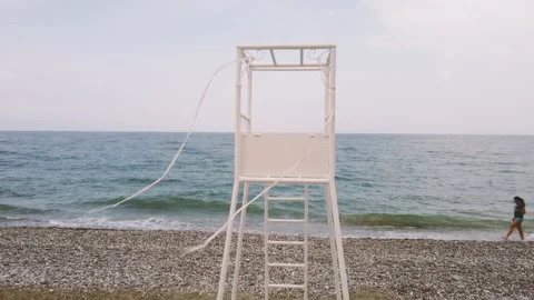 Copter flies off the rescue tower, between the umbrellas from the sun Stock Footage 181451567