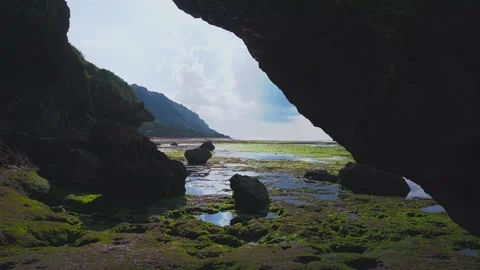 The copter flies through the rocks and opens up to a view of crashing waves and Vidéo 267956498
