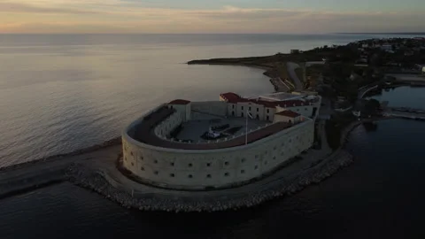 Copter flight around the old castle on a narrow isthmus in the sea channel Stockbeeldmateriaal 158974711
