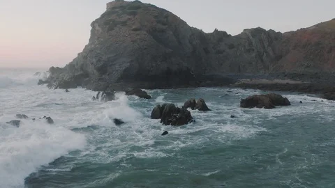 Copter flying over wave with foam. Sea wave is breaking on the rocks. Stock-Footage 128630809