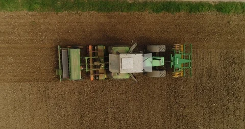 Copter moving up. View at the tractor working on the harvest field in German. 4k Stock Footage 87474722