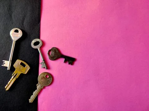 Copy space of different sizes of door keys on pink background. Selective focu Stock Photos