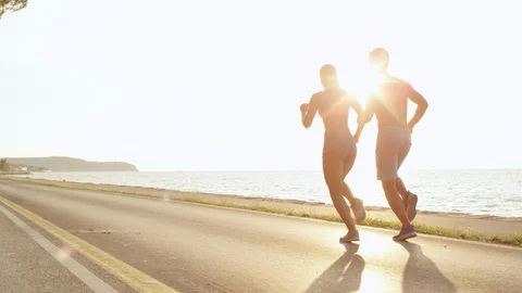 COPY SPACE: Fit young training partners jogging down the empty asphalt road. Stock Footage 94995746