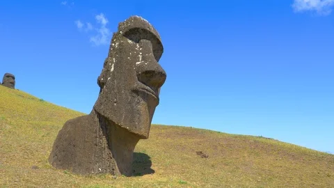 COPY SPACE: Flying shot of interesting moai statues scattered around grassy hill Stock Footage 111232146