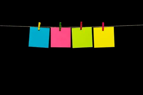 Copy space. Four sheets of paper yellow, turquoise and pink with clothespins Stock Photos