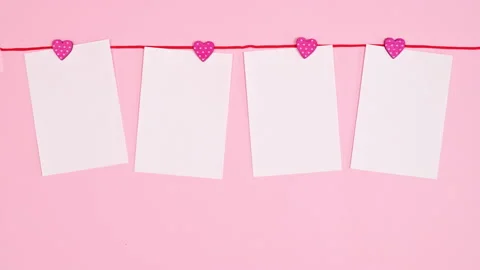 Copy space papers hanged on red rope on pastel pink background. Stop motion. Stock-Footage 230719269