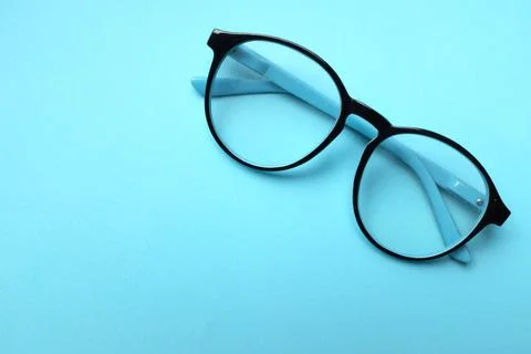 Copy space round black Eye Glasses isolate on a blue pastel Background Stock Photos