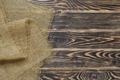 Copy space on a rustic  wood tabletop painted black and burlap on a side. Stock Photos