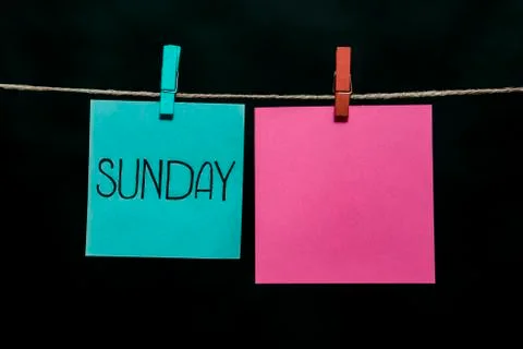 Copy space. Sunday. Note is written on a azure sticker. Two sheets of paper Stock Photos