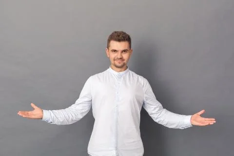 Copy Space for Text or Product. Young man studio standing isolated on grey hands Stock Photos