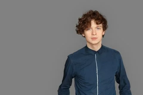 Copy Space for Text or Product. Teenager boy standing isolated on grey looking Stock Photos