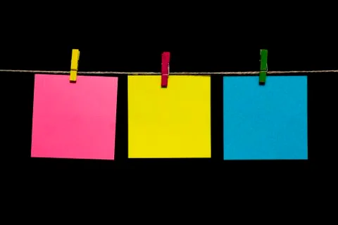 Copy space. Three sheets of paper yellow, turquoise and pink with clothespins Stock-Fotos
