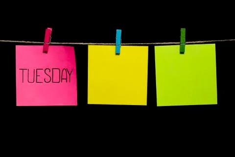 Copy space. Tuesday. Note is written on a pink sticker. Three multicolored Stock-Fotos