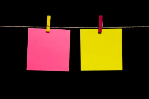 Copy space. Two sheets of paper yellow and pink with clothespins hang on a rope. Foto stock