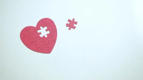 Copy spase. One piece of missing part from red puzzle heart shaped jigsaw on Stock Photos