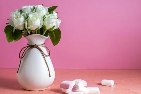 Copyspace with colorful mini marshmallows on a table next to white roses on a Stock Photos