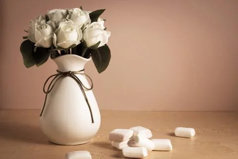 Copyspace with colorful mini marshmallows on a table next to white roses on a Stock Photos