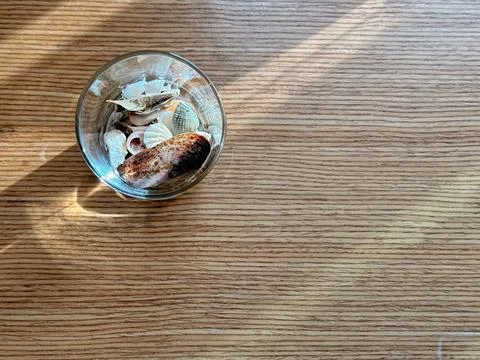 Copyspace with glass of shells on wood table Stock Photos