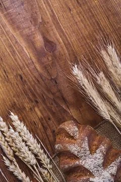 Copyspace image loaf of bread and wheat ears on old wooden board 스톡 사진
