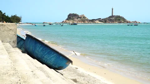 Coracle boats moored on Vietnamese beach, Ke ga lighthouse in background. Stock-Footage 200093351
