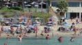 Coral Bay sandy beach with resting people on the sand and in water, Cyprus HD Footage