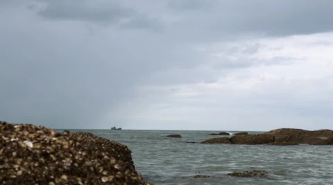 Coral rock in the ocean with a fishing boat Stock Footage