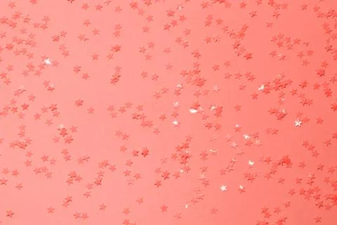 Coral sequins on a orange background. Stock Photos