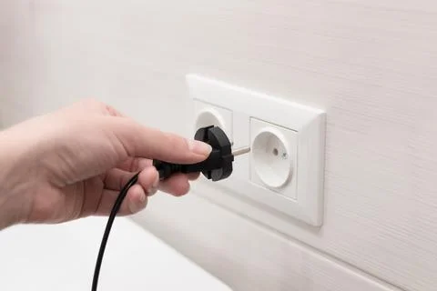 Cord with plug from the electrical device to the socket. close-up Foto stock