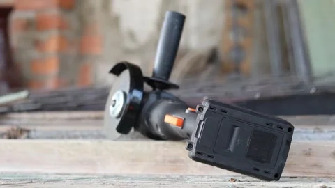 Cordless angle grinder on a wooden surface, power tool close-up Stock Footage 346383494