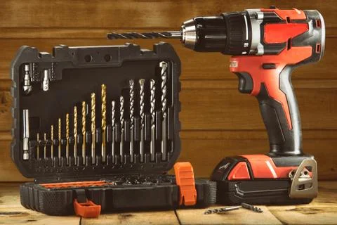 Cordless drill driver in red with rubberized handle in profile with drill bits Stockfoto's