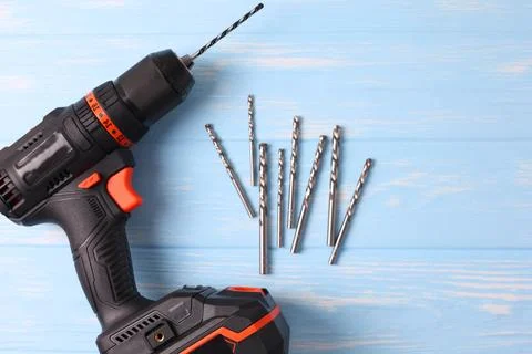 Cordless Drill Featuring Various Drill Bits Set Against a Vibrant Blue Foto stock