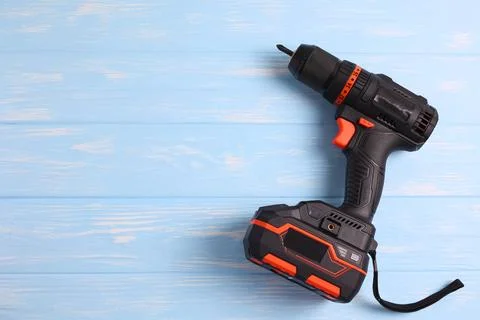 Cordless Drill Featuring Various Drill Bits Set Against a Vibrant Blue Foto stock