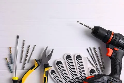 Cordless Drill Featuring Various Drill Bits Set Against a Vibrant Blue Stock Photos