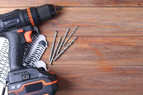 Cordless Drill Featuring Various Drill Bits Set Against a Vibrant Blue Foto stock