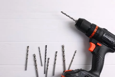 Cordless Drill Featuring Various Drill Bits Set Against a Vibrant Blue Stock Photos
