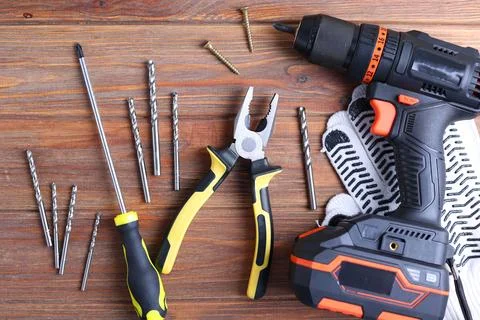 Cordless Drill Featuring Various Drill Bits Set Against a Vibrant Blue Stock Photos