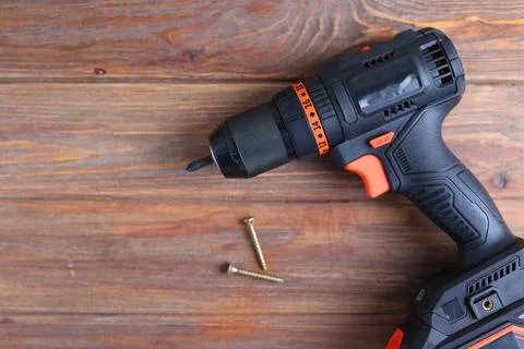 Cordless Drill Featuring Various Drill Bits Set Against a Vibrant Blue Stock Photos