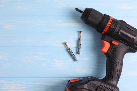 Cordless Drill Featuring Various Drill Bits Set Against a Vibrant Blue Stock Photos