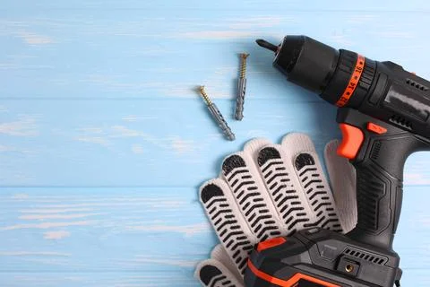 Cordless Drill Featuring Various Drill Bits Set Against a Vibrant Blue Stock Photos