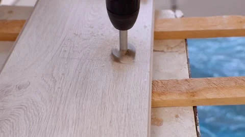 Cordless drill with forstner bit drilling hole in laminate flooring Vidéo 326143206
