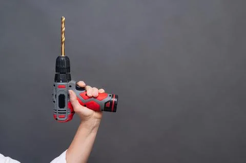 Cordless drill with long bit held in hand raised, power tool raised isolate.. Stock Photos
